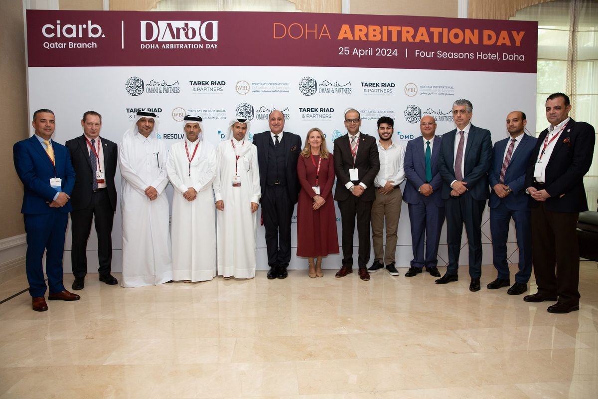 Group photograph in front of the event backdrop at the 1st Doha Arbitration Day