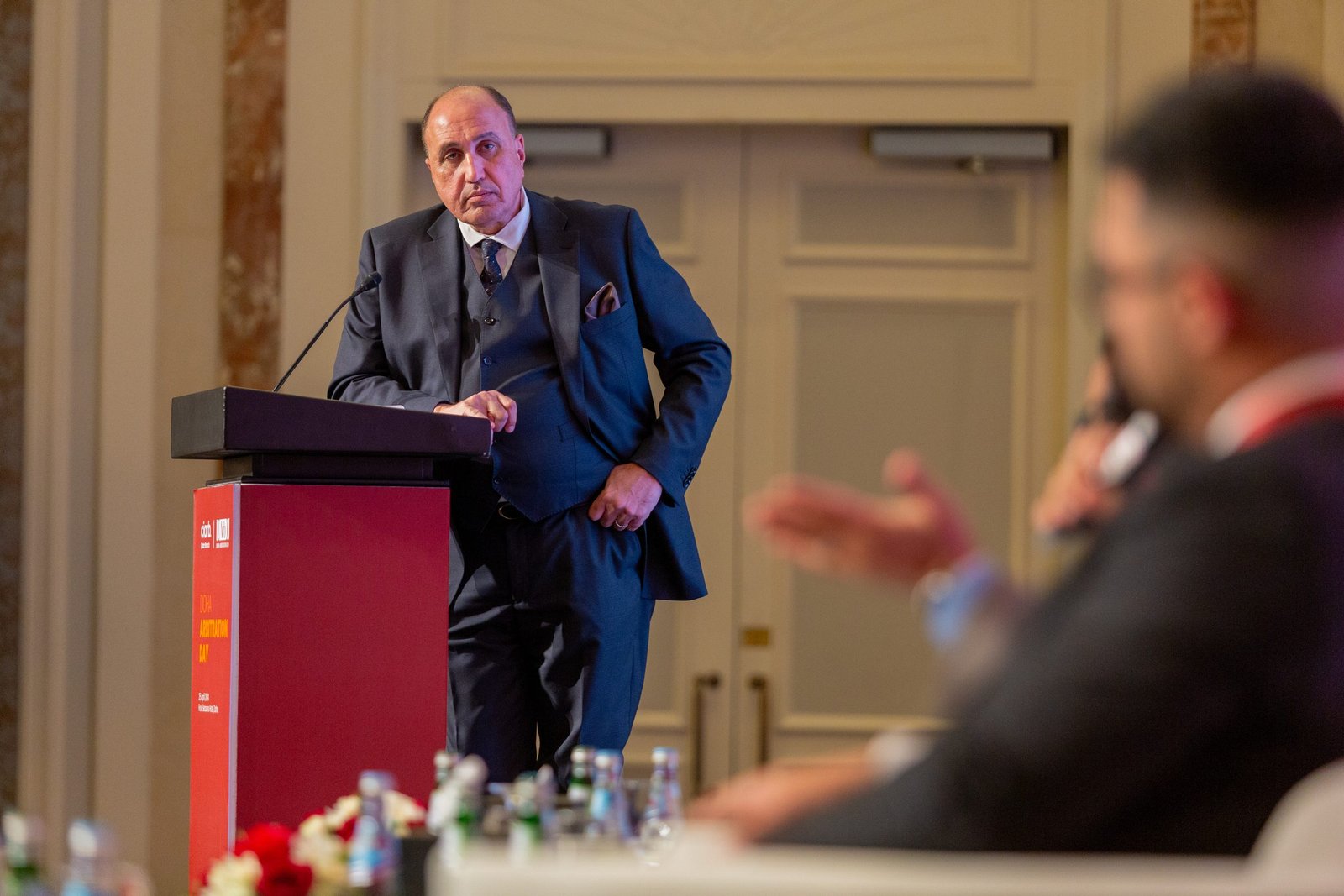 Speaker at the podium at the 1st Doha Arbitration Day